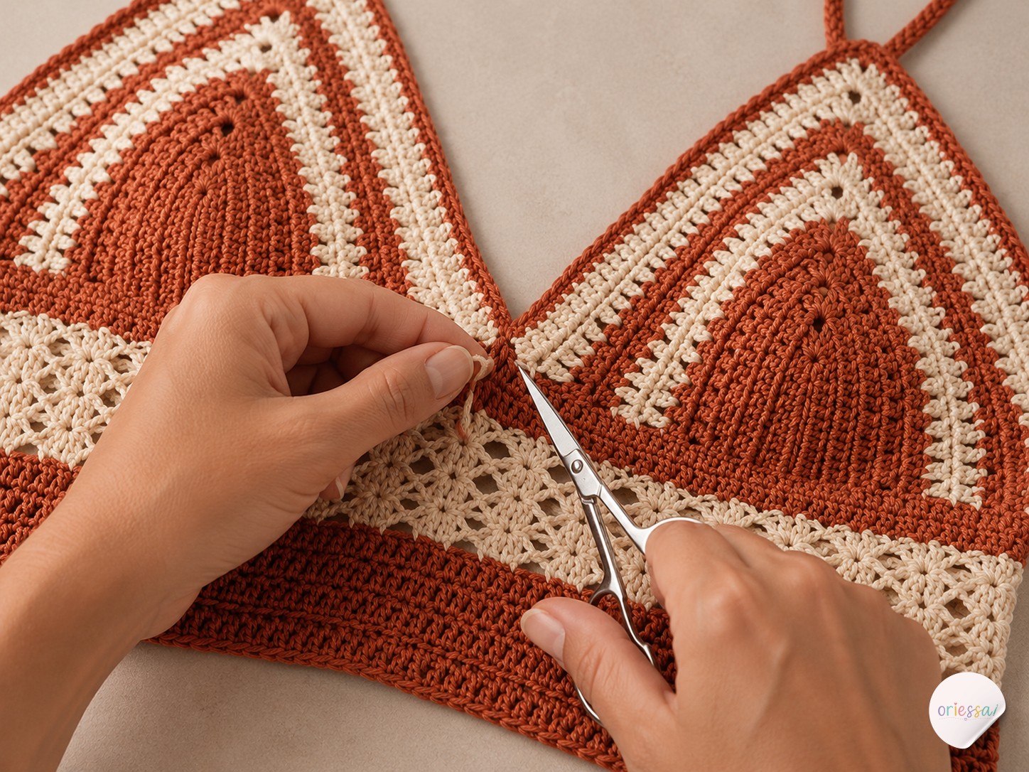 Hands weaving and trimming yarn ends with scissors