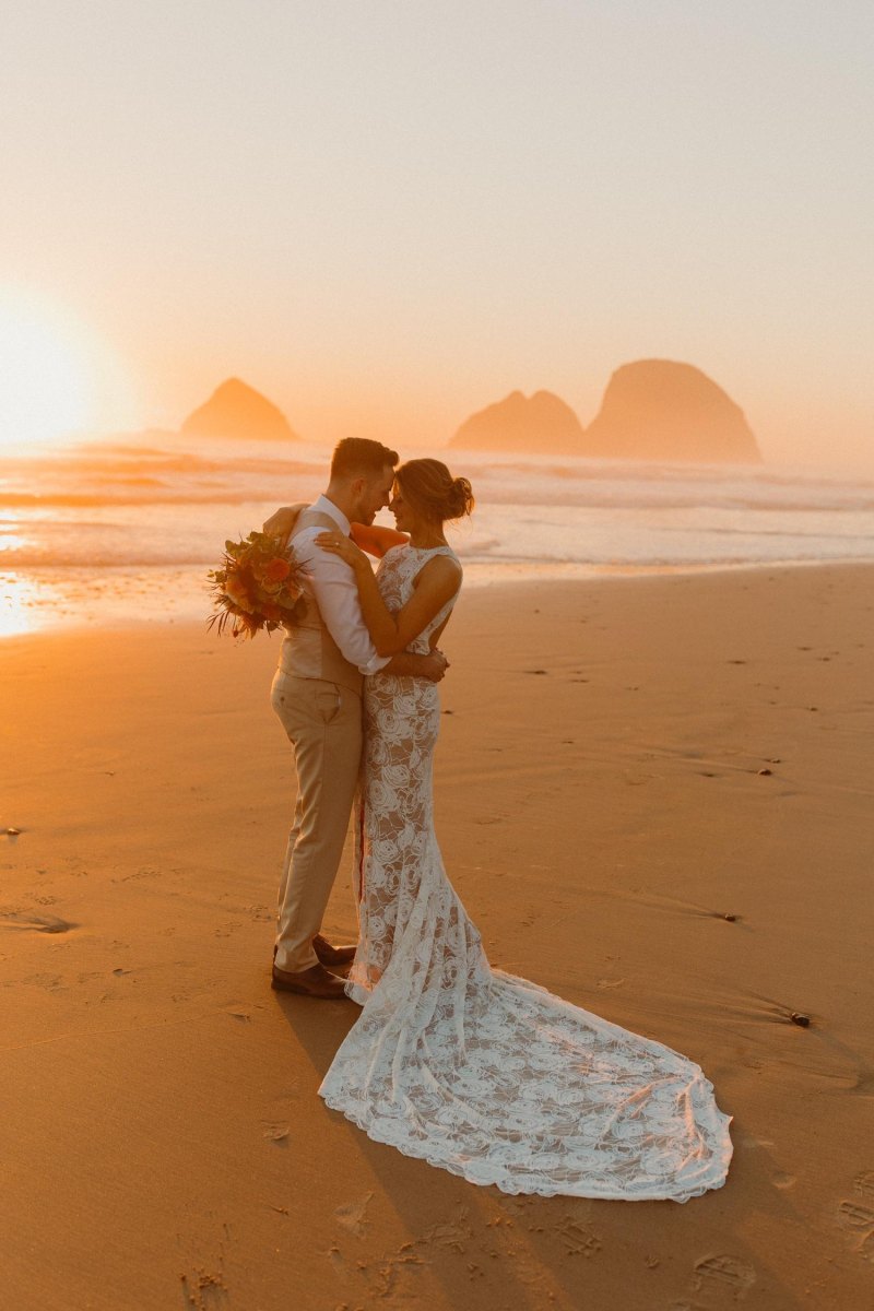Couple celebrating beach sunset elopement