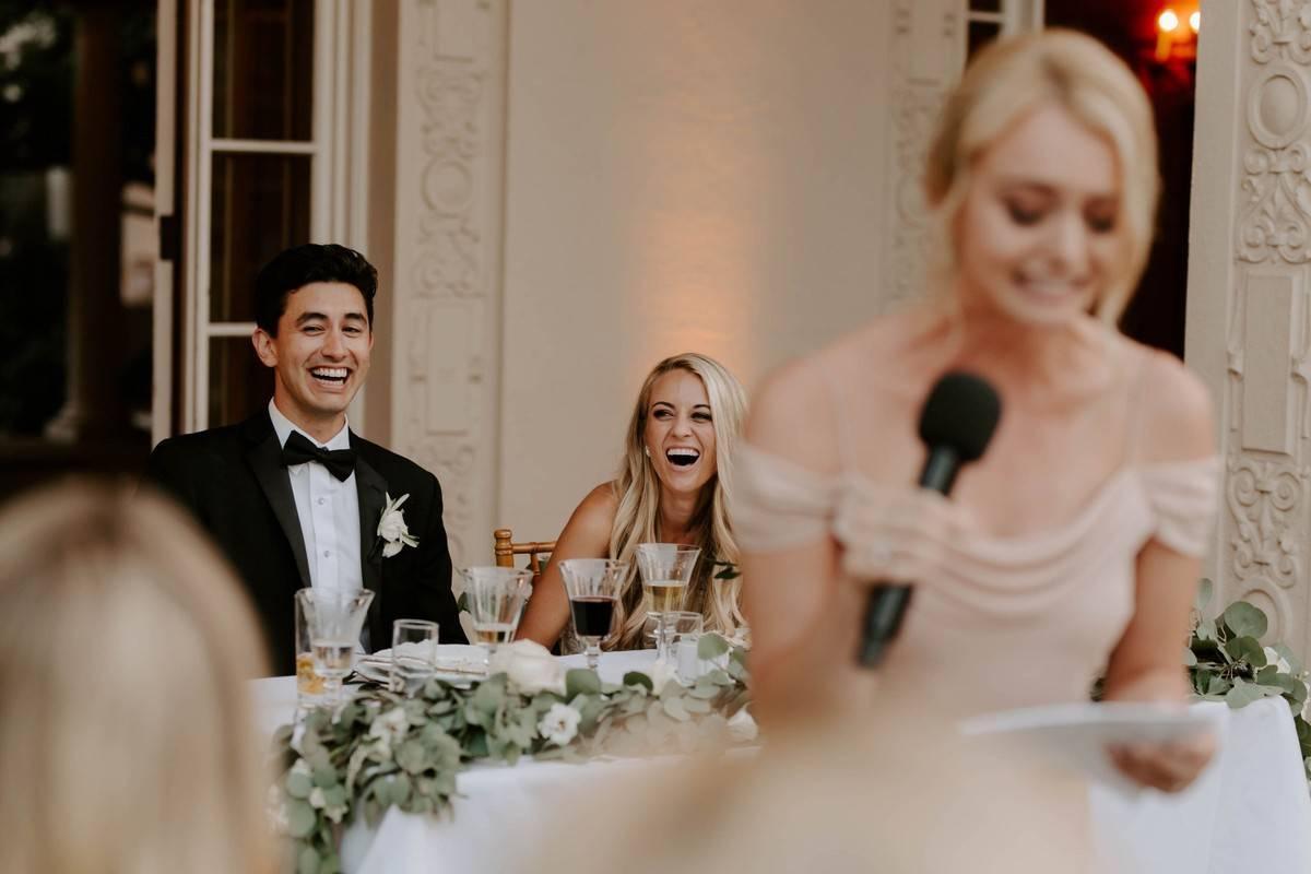 Guests laughing during wedding toast