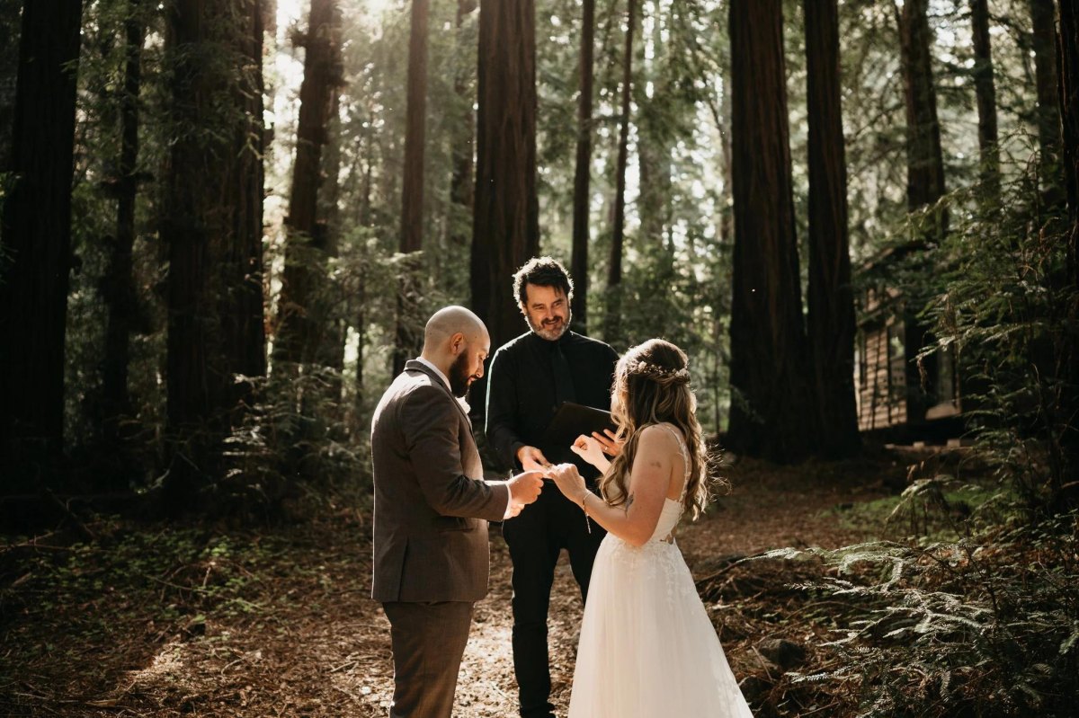 Couple exchanging vows in forest ceremony