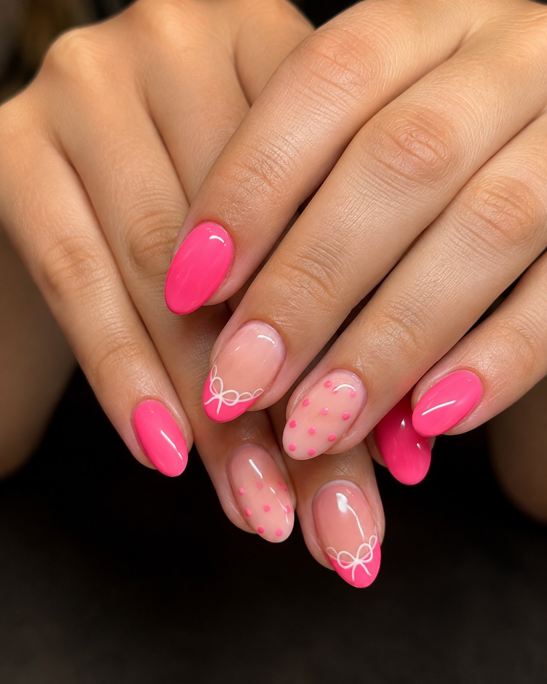 Hot pink short nails styled with delicate white bow line art and soft pink polka dots