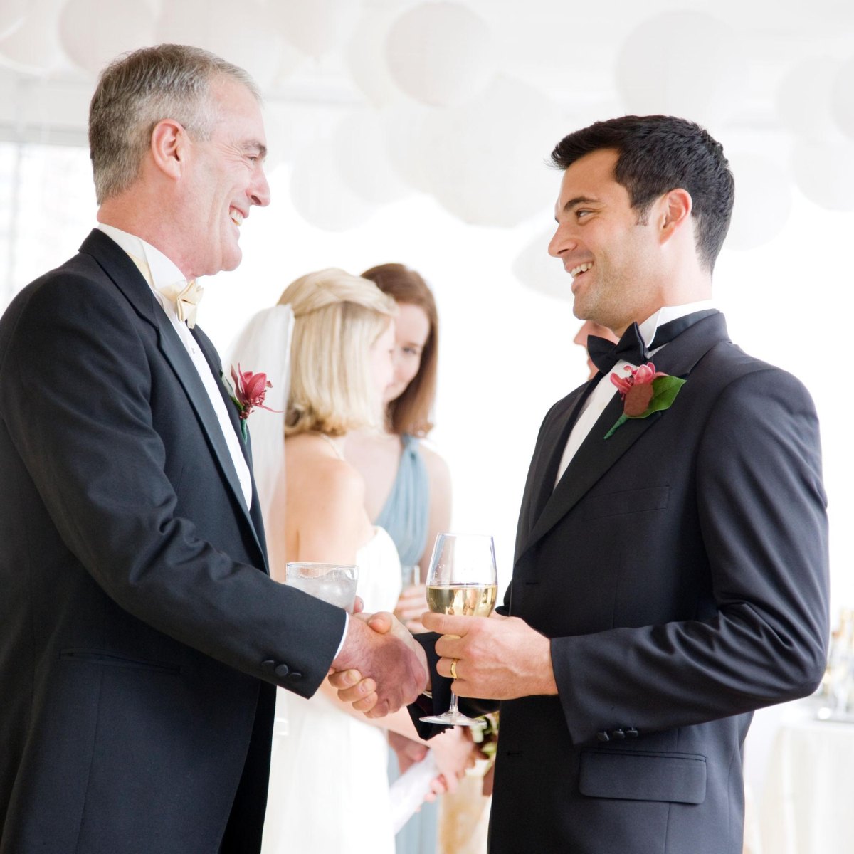 Father congratulating groom at wedding